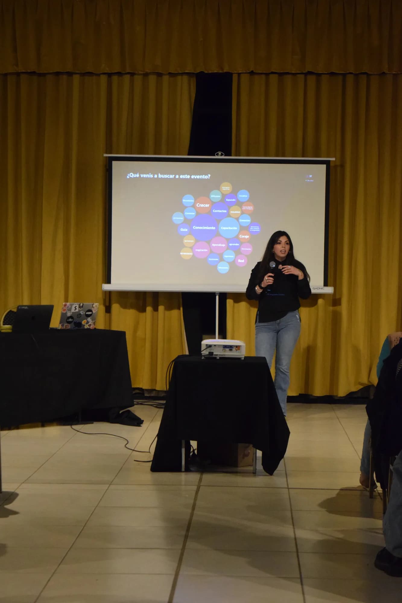 Presentadora explica una consigna en la pantalla