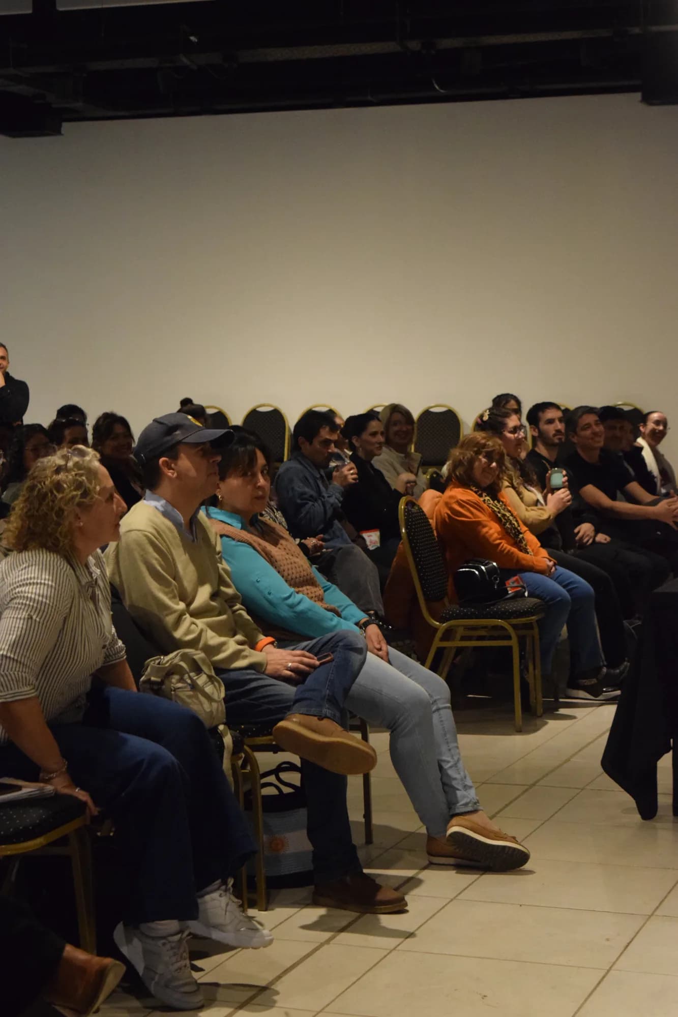 Asistentes sentados escuchan atentos