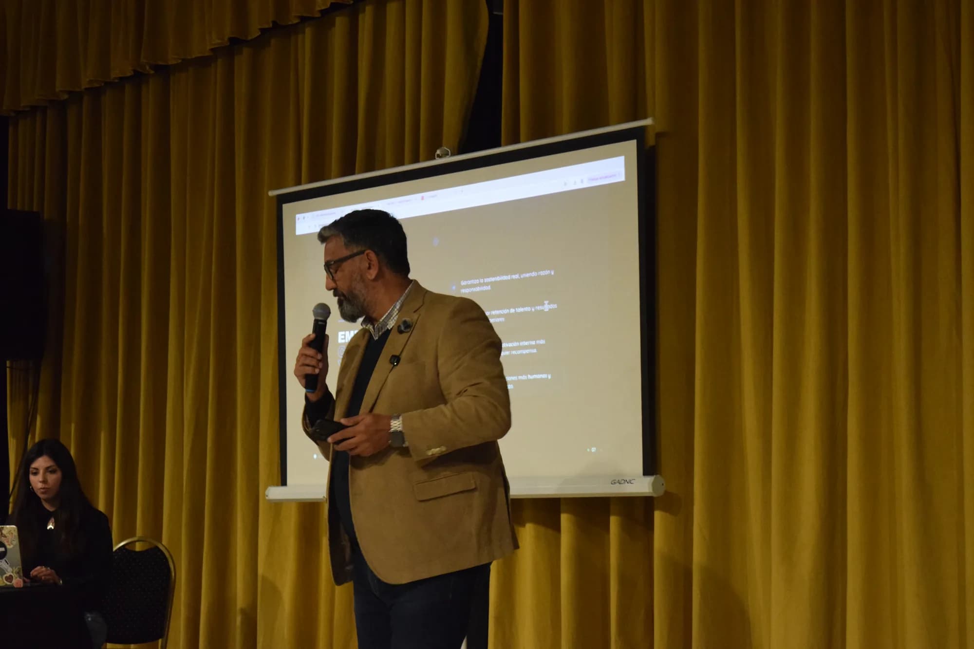 Orador explica una presentación frente a la pantalla
