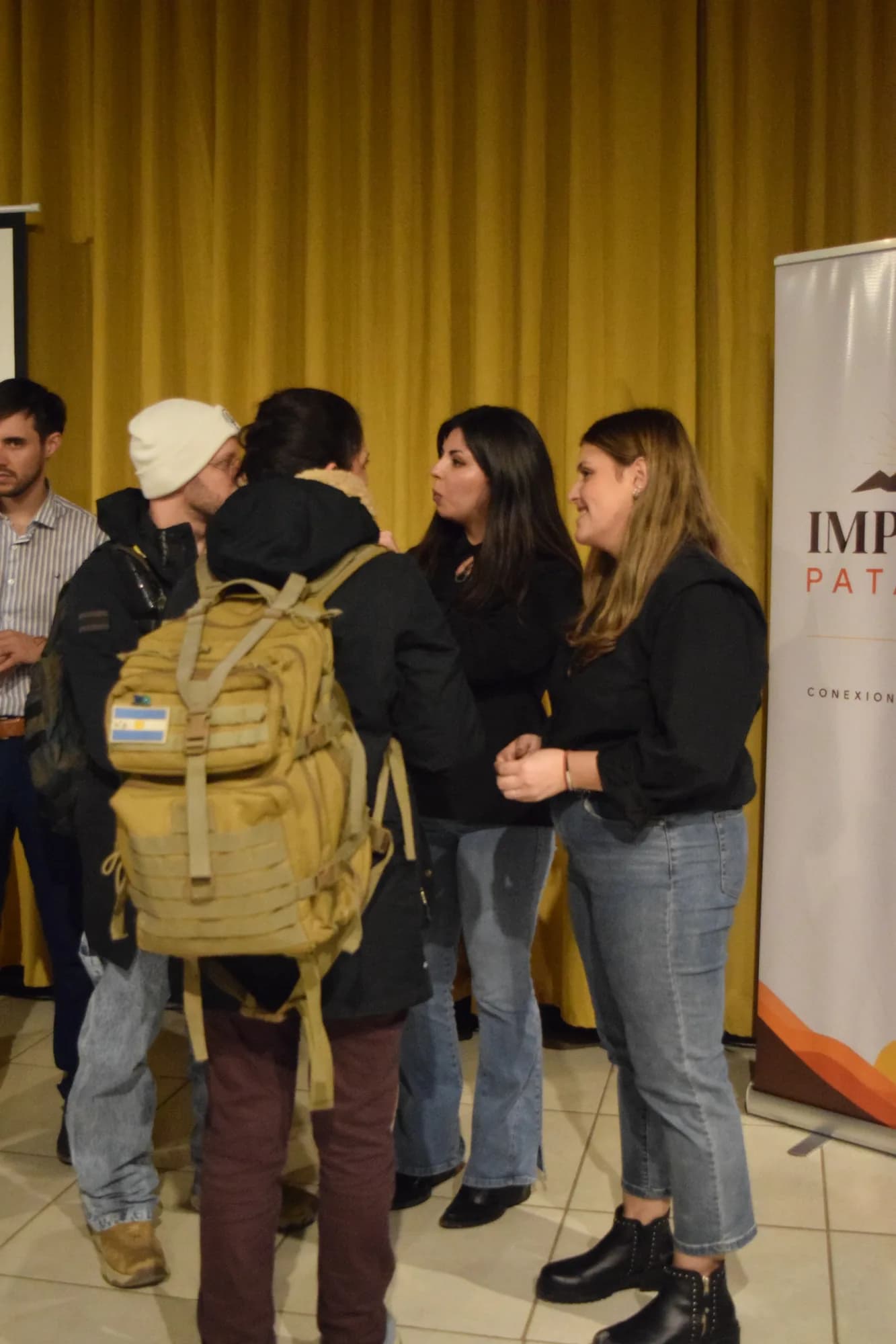 Asistentes conversan junto al banner